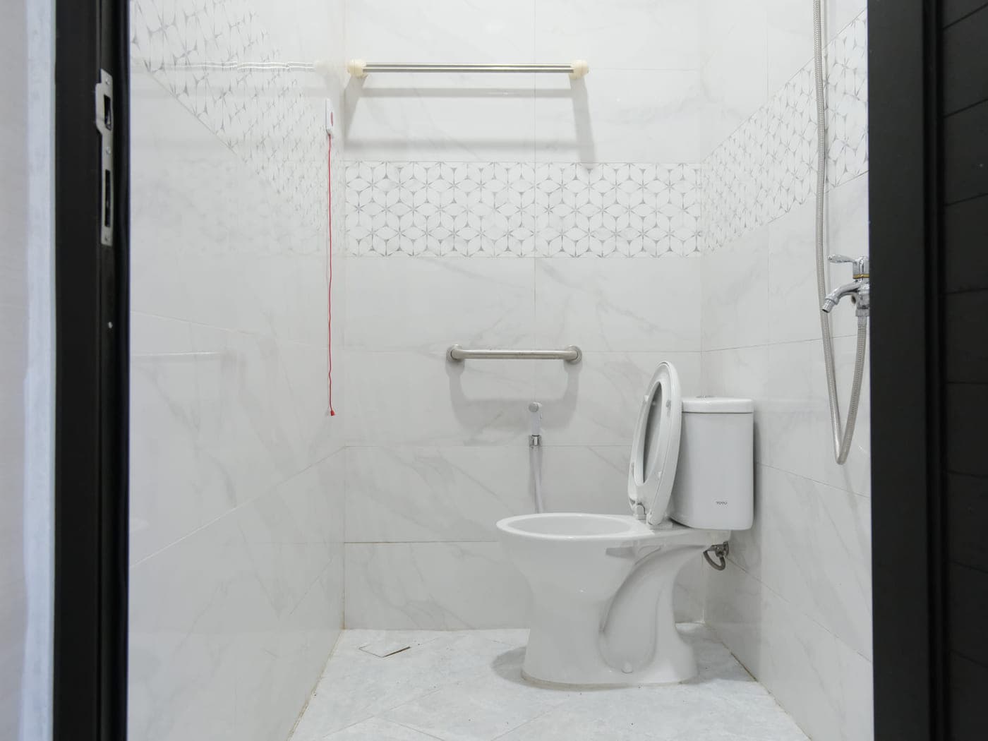 Kamar mandi dalam dengan pegangan tangan dan shower